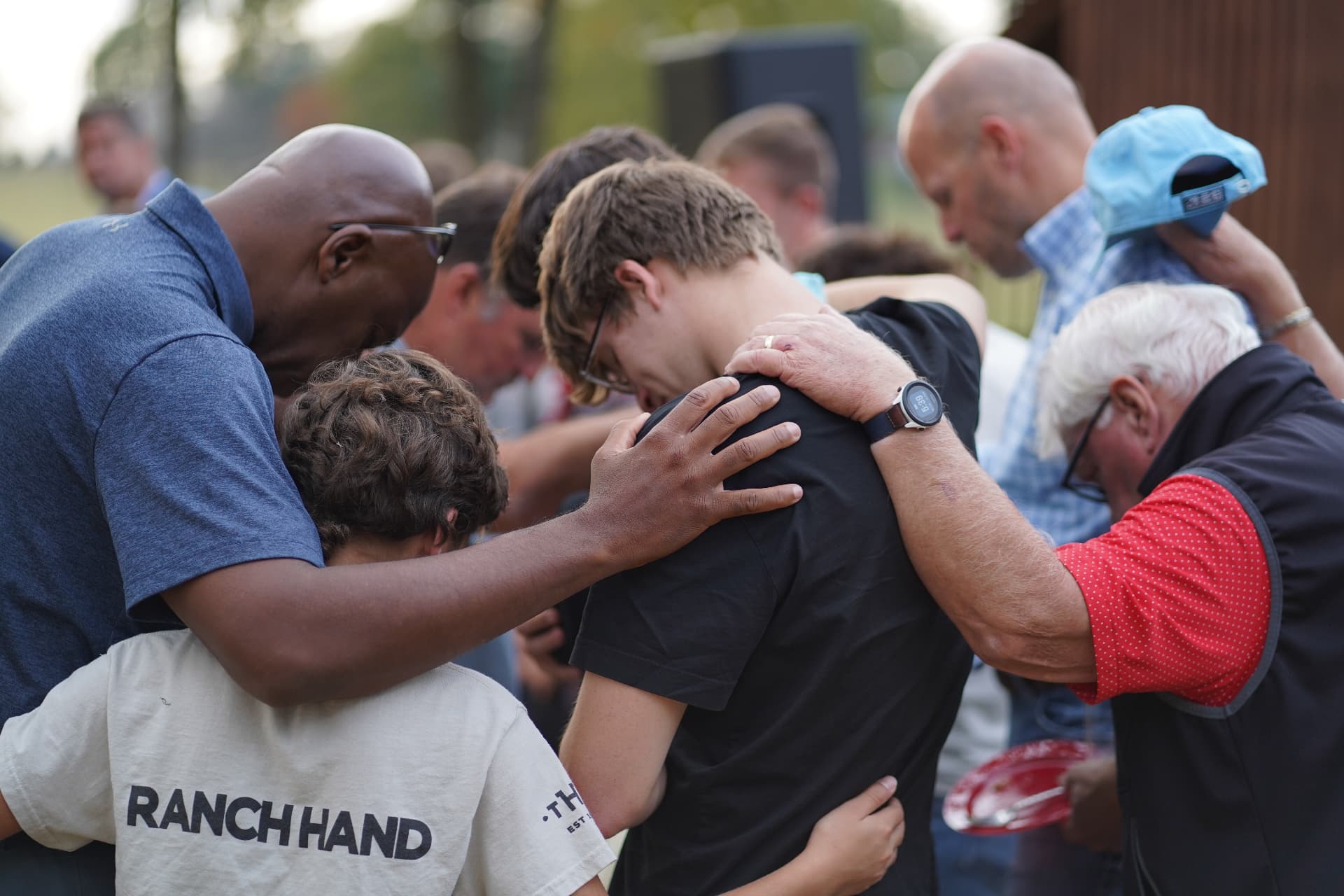 Mentors and youth embracing in prayer at Timothy Hill Ranch